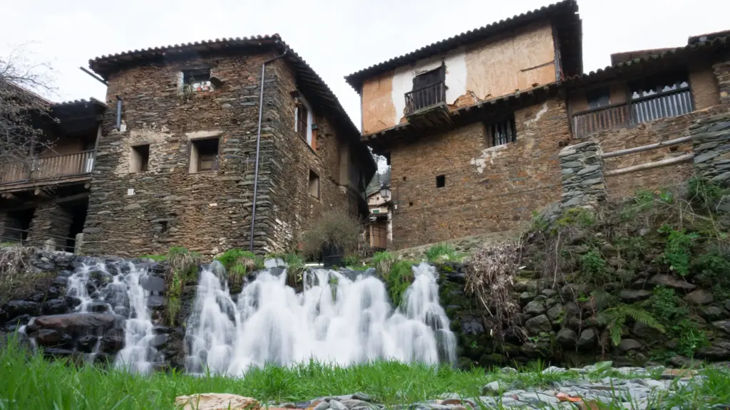 Casas de piedra y pizarra de Robledillo de Gata junto a una pequeña cascada, Sierra de Gata (Cáceres)